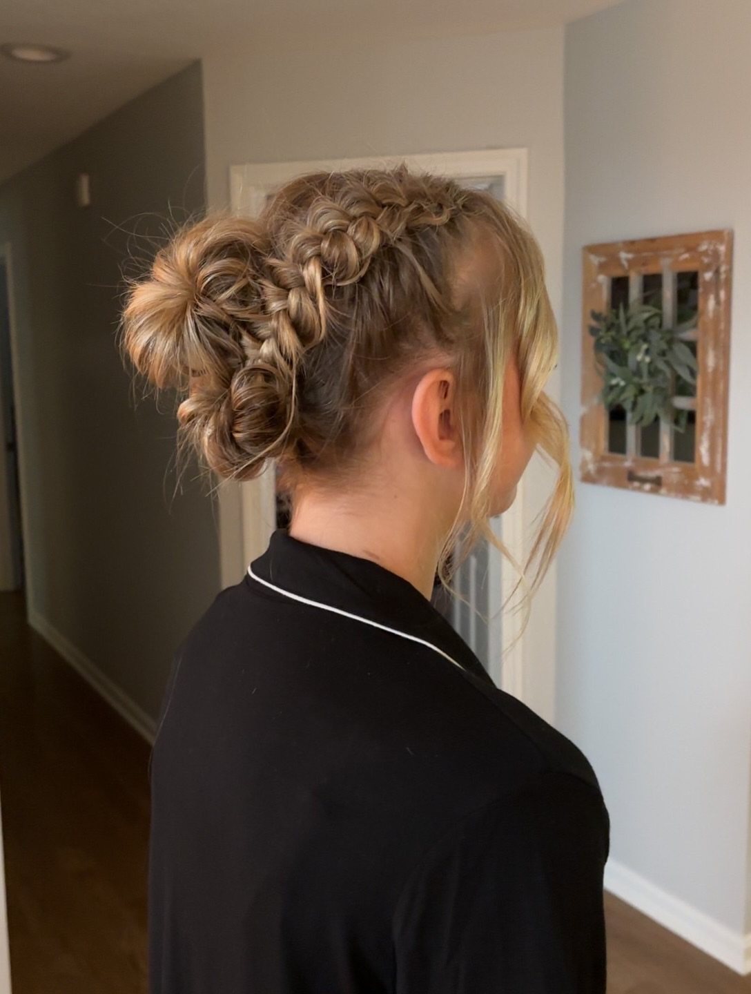 A woman with blonde hair styled in an intricate braided updo bun.