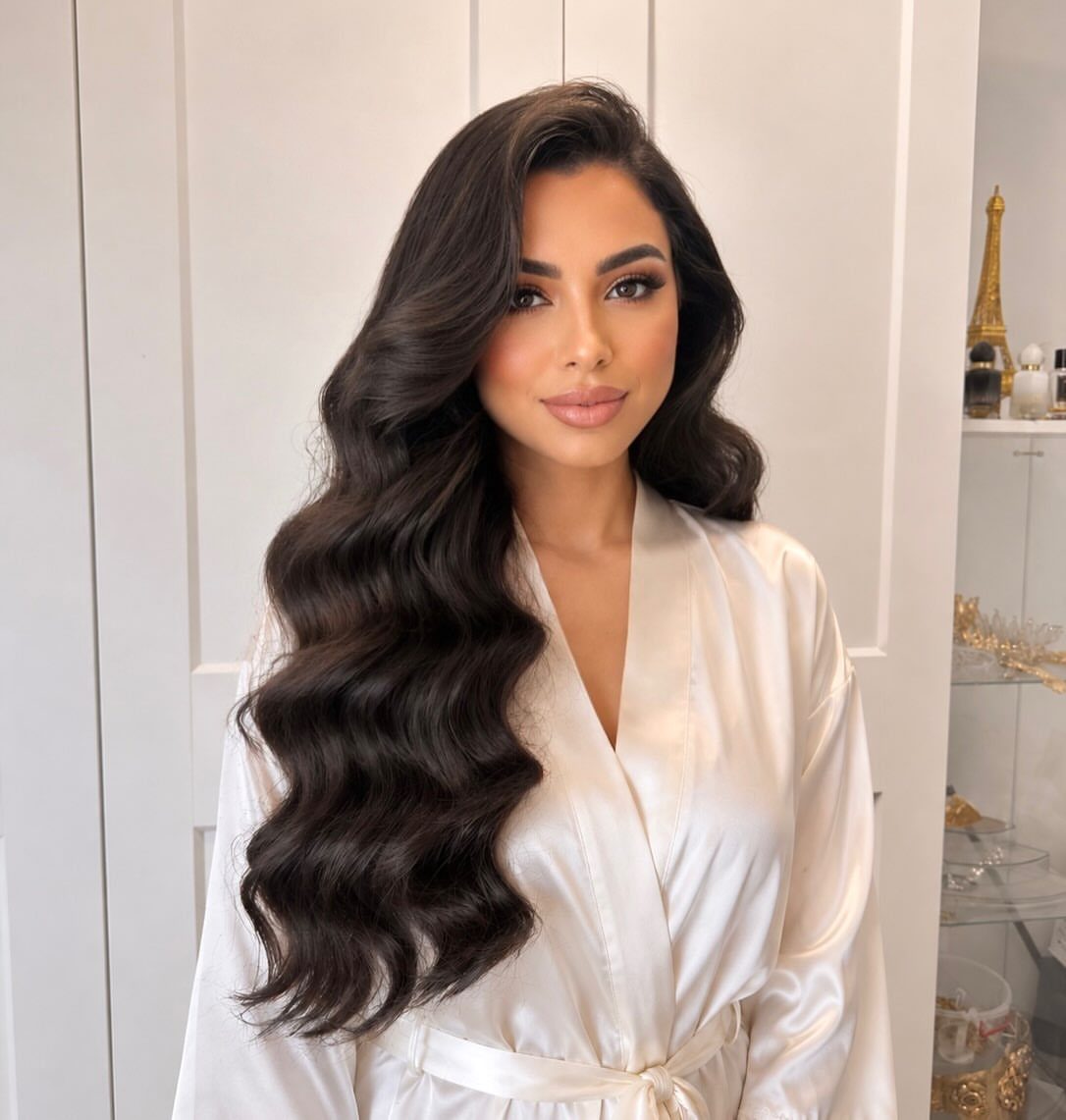 Woman with long dark brown hair styled in voluminous loose romantic waves.