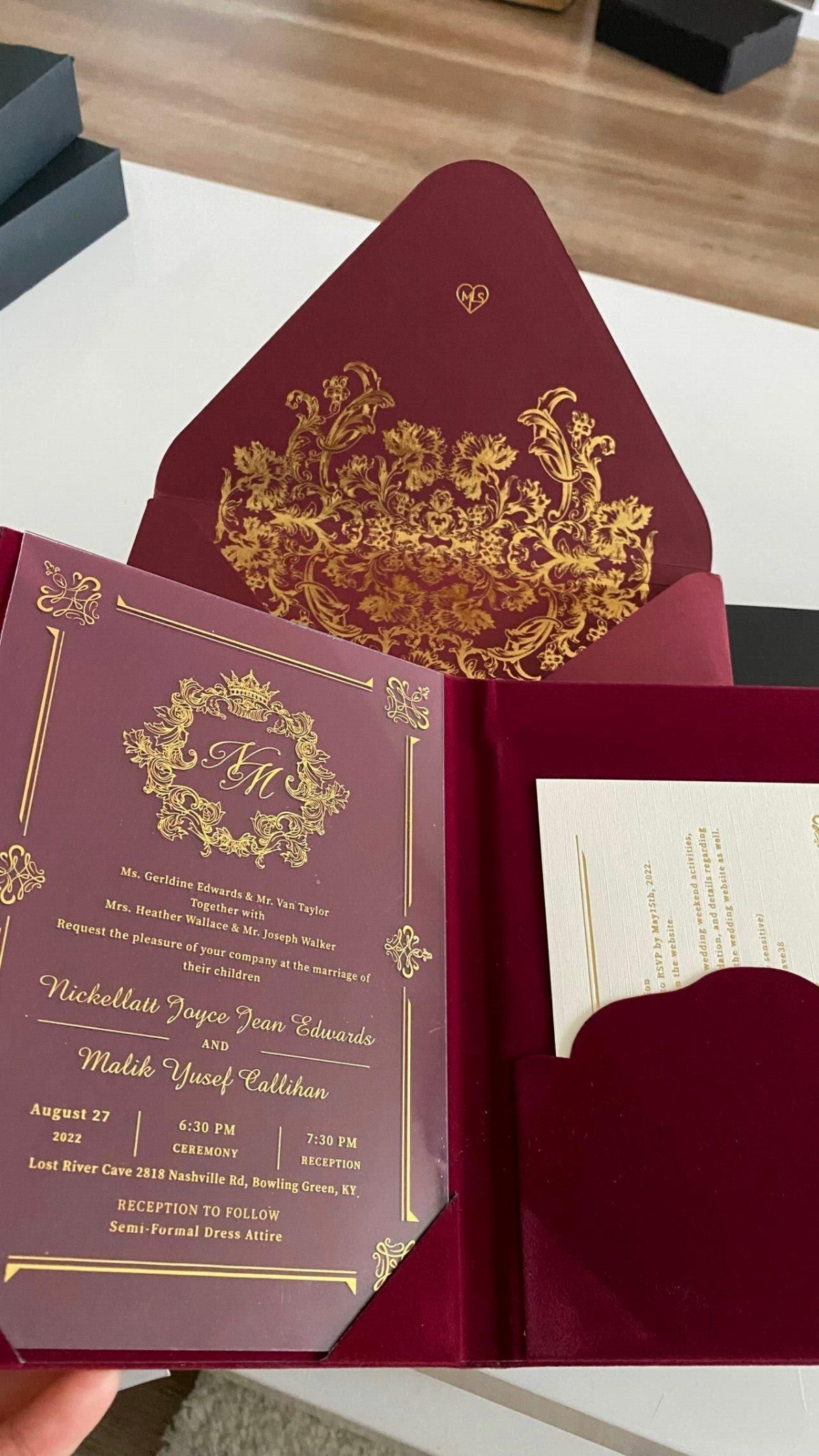 Burgundy wedding invitation with gold foil damask patterns and elegant calligraphy on a white card.