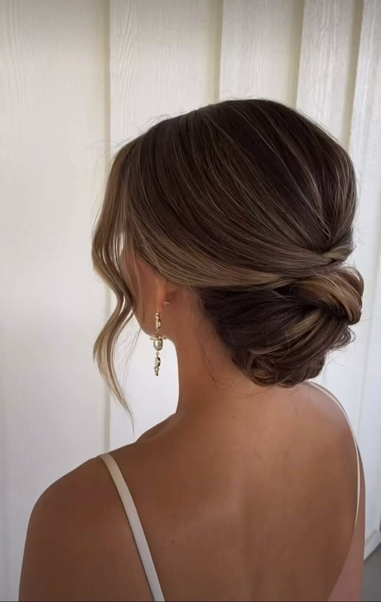 Woman with brown hair styled in a low textured bun updo