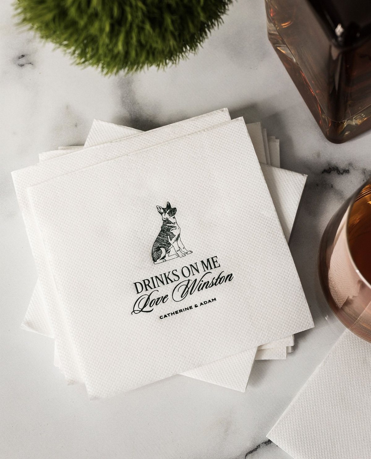 White paper napkins featuring a black sketch of a dog and custom wedding text.